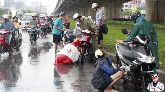 Đang đi trên đường, dừng xe để mặc áo mưa có phạm luật không? - 1