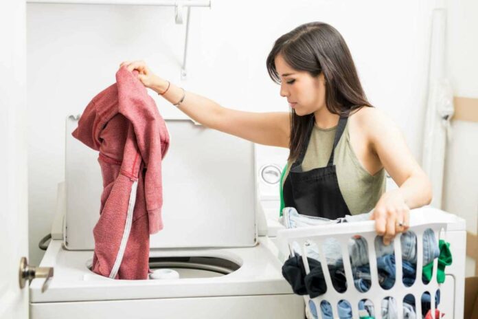 người-phụ-nữ-đang-giặt-đồ-bằng-máy-giặt.